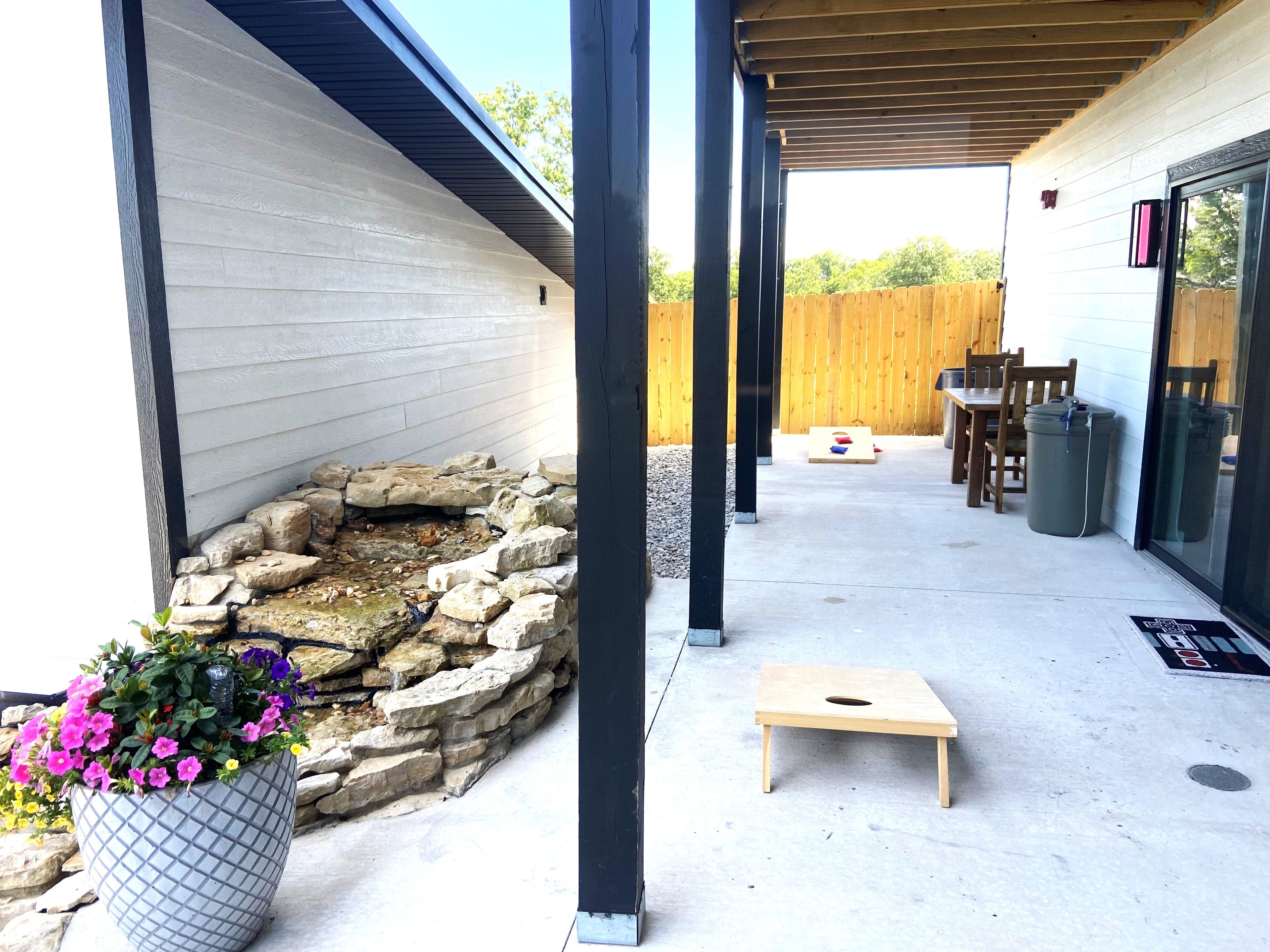 Covered patio and waterfall near the game room