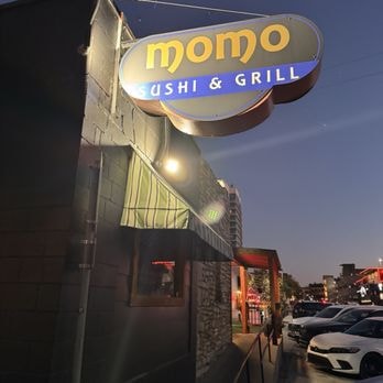 Momo Sushi & Grill exterior sign at dusk