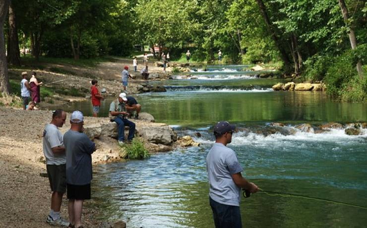 Anglers fly fishing in the clear green waters of Roaring River State Park