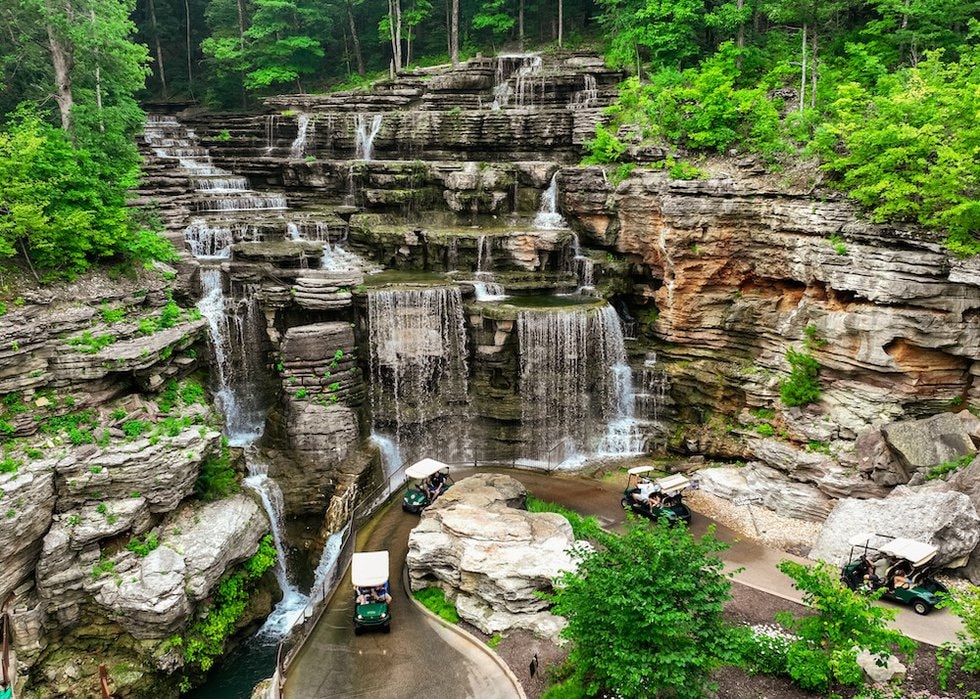 Golf carts touring through dramatic multi-tiered waterfalls and rocky canyon at Top of the Rock